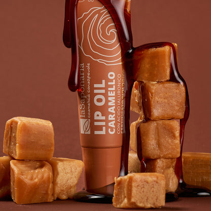 Embalagem do Óleo Labial Caramelo Biológico — Cor, Volume e Nutrição da La Saponaria junto com pedaços de caramelo sólido e caramelo líquido a escorrer pelo produto.
