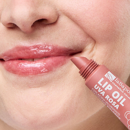 Imagem de lábios brilhantes e rosados e embalagem do Óleo Labial Biológico Uva Rosa — Cor, Volume e Nutrição da La Saponaria