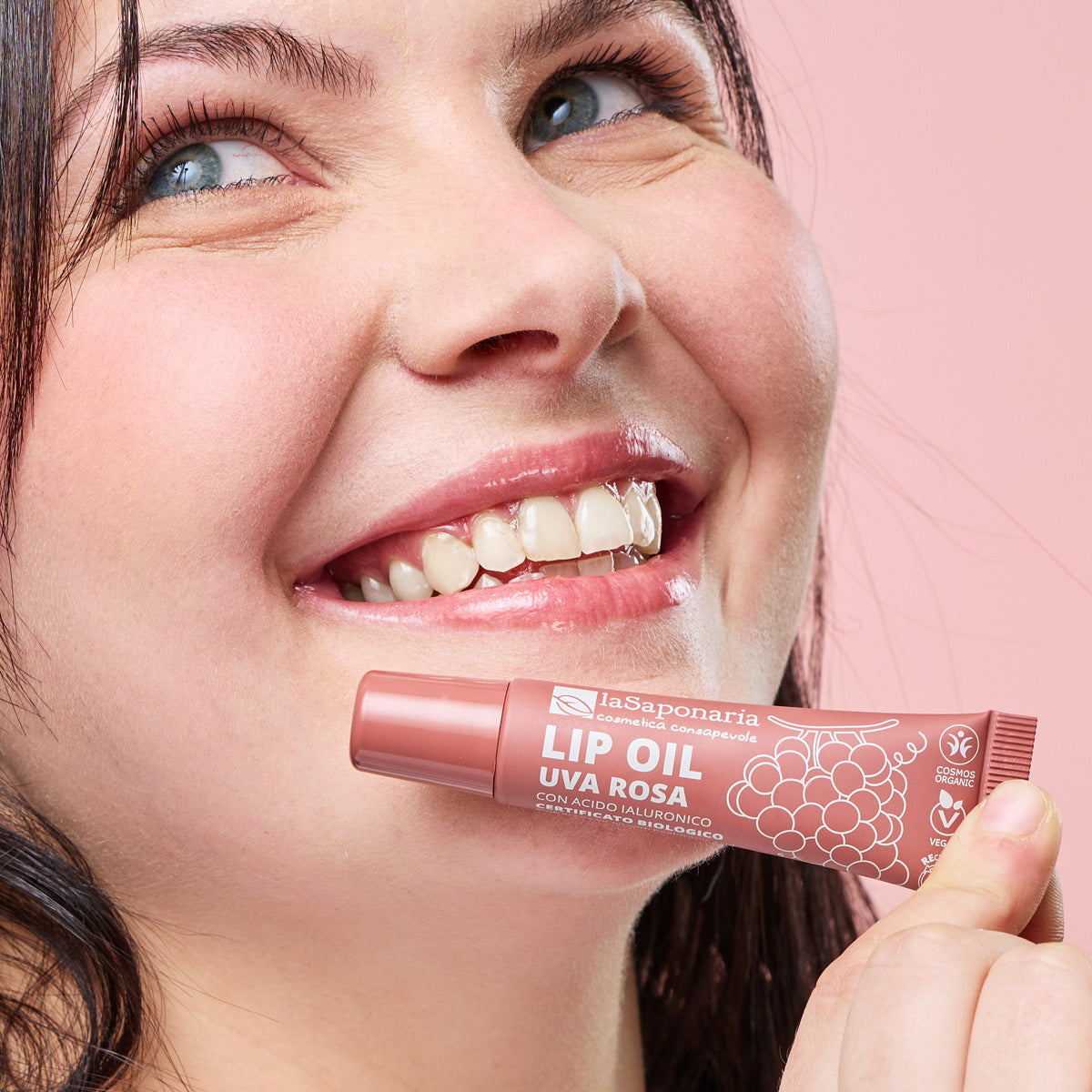 Imagem de lábios brilhantes e rosados e embalagem do Óleo Labial Biológico Uva Rosa — Cor, Volume e Nutrição da La Saponaria