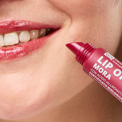 Imagem de lábios com cor vibrante vermelho escuro e embalagem do Óleo Labial biológico Amora — Cor, Volume e Nutrição da La Saponaria