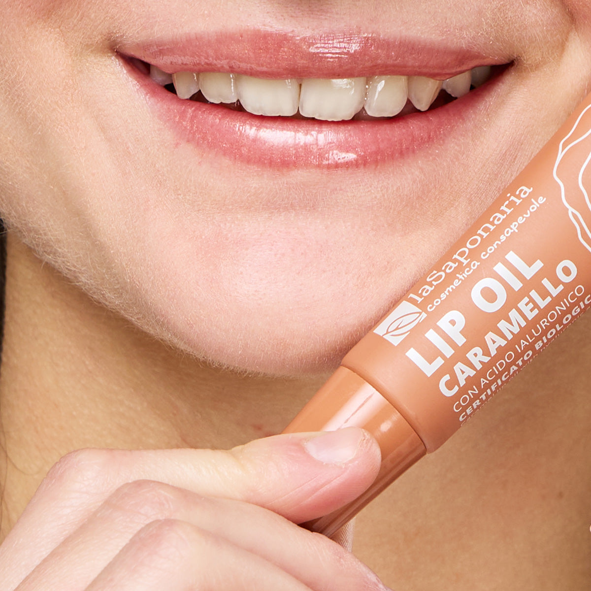 Lábios brilhantes e com cor nude quente e embalagem do Óleo Labial Caramelo Biológico — Cor, Volume e Nutrição da La Saponaria